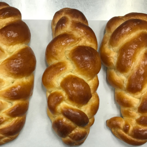 a photo of three loaves of challah bread