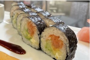 photo of kosher sushi roll on a plate including salmon, cucumber, and mango