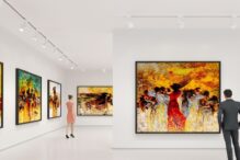 Stock image of an art museum with people walking and viewing the artwork