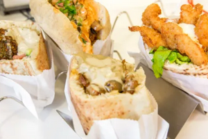 photo of pita sandwiches containing falafal, hummus, sabich and chicken