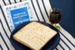 Stock image of matzah, a Haggadah, and a glass of wine