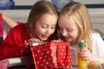 Photo of two girls digging through a lunch box