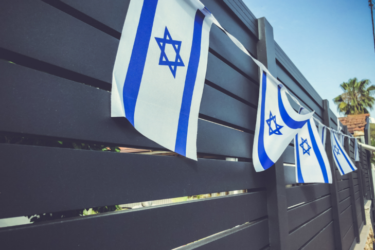 Stock image of Israeli flags hanging on a fence