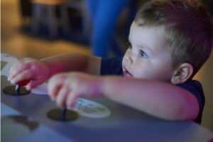 photo of a young child playing with an interactive exhibit at a museum