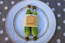 plate with food cut and placed in the shape of a torah using cucumber, cheese and olives