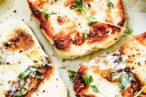 photo of a plate full of grilled halloumi cheese sprinkled with fresh herbs