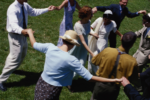 Image of a group of people dancing hand in hand in a circle