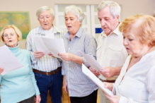 Image of a group of seniors singing with song sheets