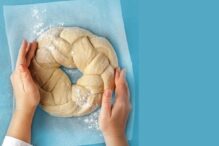 photo of a person shaping a round braided challah