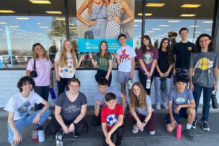 Image of Hebrew High students posing outside a thrift store during Care-A-Van