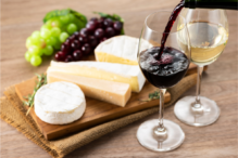 Image of two glasses of wine with cheese and grapes