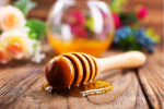 Image of a honey stick with honey on it lying on a table