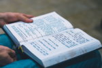 Image of a person holding a prayer book on their lap