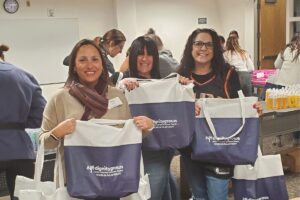 Volunteers with Women IN Philanthropy pose for a picture holding up the Dignity Grows bags that are filled with hygiene products and donated to those in need