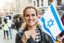 Woman holding an Israeli flag and smiling